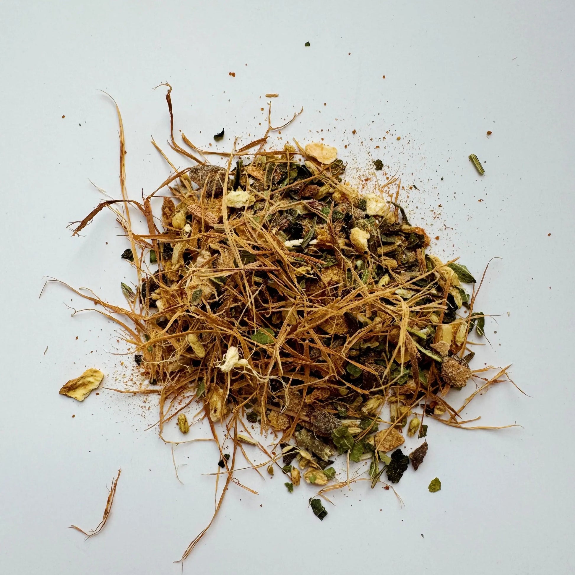 A close-up of loose leaf Immunity Tea blend featuring organic herbs like astragalus root, ginger, wild cherry bark, and echinacea. Displayed on a wooden spoon, the mix includes natural textures and earthy tones, ideal for wellness and immunity.